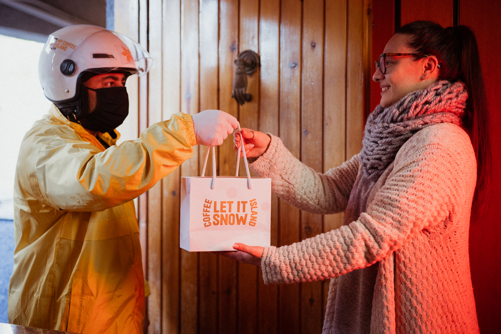 Delivery boy holding Coffee Island's Christmas bag.
